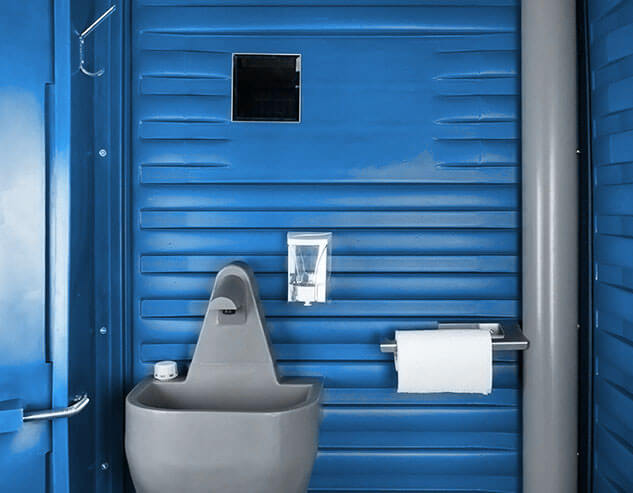 Держатель для полотенец, зеркало и дозатор для мыла в синей туалетной кабине «Люкс».