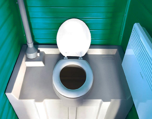 Накопительный бак для отходов и обогреватель, установленые внутри зелёной туалетной кабины «Варм».
