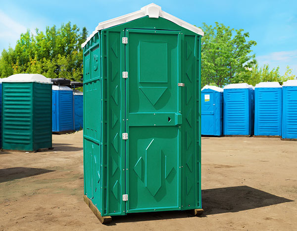 Зелёная туалетная кабина «Стандарт Pro» в окружающей среде, вид спереди.