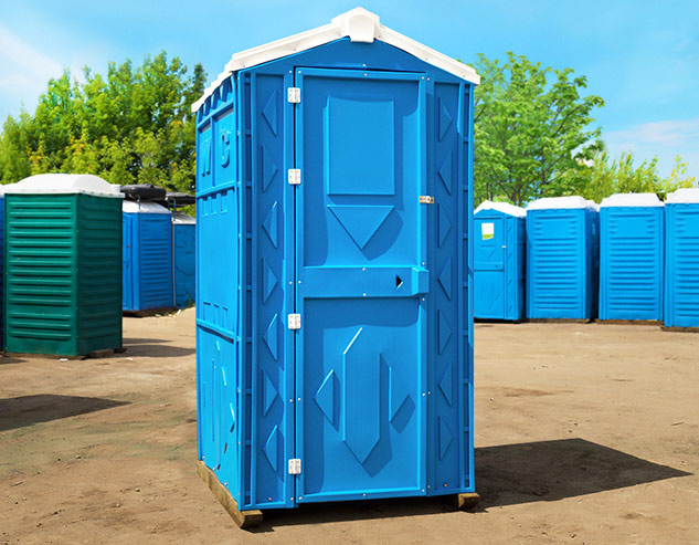 Синяя туалетная кабина «Стандарт Pro» в окружающей среде, вид спереди.